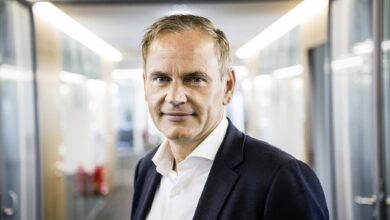Oliver Blume in weißem Hemd und dunklem Sakko lächelt in die Kamera