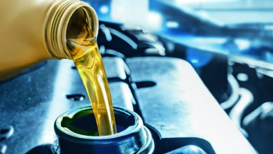 Pouring motor oil from plastic canister in car repair service center. Regular and routine vehicle maintenance utilizing engine oil is essential for achieving optimal performance levels