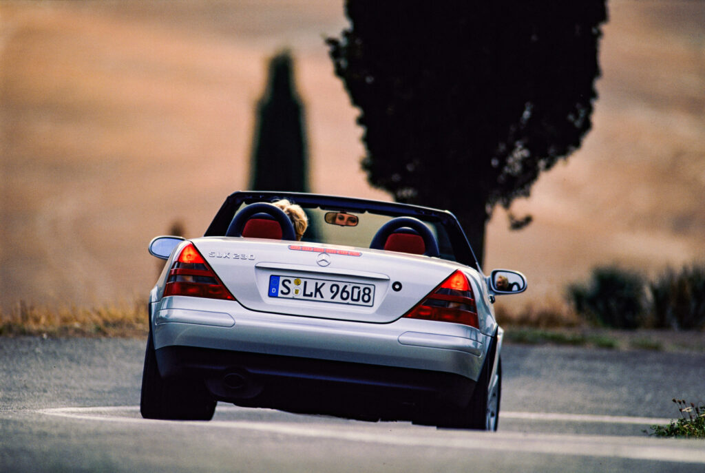 Mercedes-Benz SLK 230 der Baureihe 170. Fahraufnahme von hinten. Das Typkennzeichen links auf dem Heckdeckel trägt die Ersatzteilnummer A 170 817 02 15. (Fotosignatur der Mercedes-Benz Classic Archive: B95F2655) Mercedes-Benz SLK 230 of the 170 model series. Driving shot from rear. The model badge on the left side of the boot lid bears the spare part number A 170 817 02 15. (Photo index number in the Mercedes-Benz Classic Archive: B95F2655)